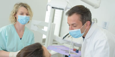 Home dentist and hygenist helping patient