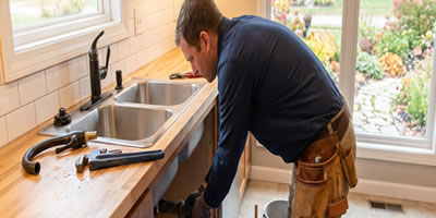 Home plumber working on residential sink